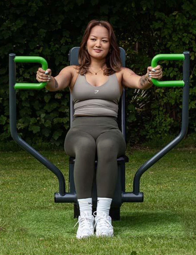 Individual outdoor chest press station in use